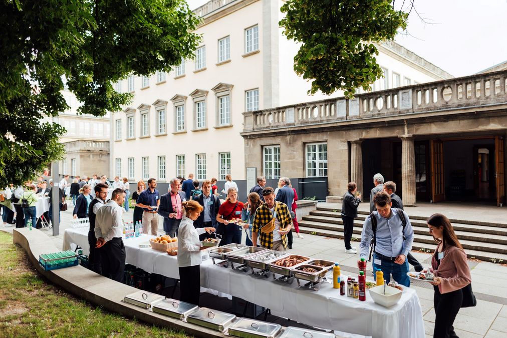 zur Vergrößerungsansicht des Bildes: Grillbuffet, dahinter stehen Gäste und nehmen sich Speisen und Getränke