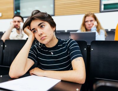 Studentin sitzt nachdenklich im Hörsaal und stützt sich auf ihren Arm, Foto: Christian Hüller