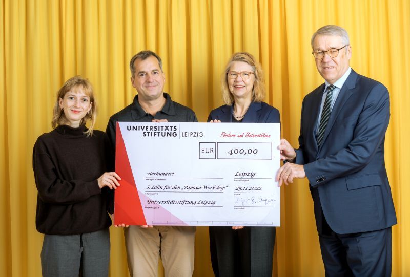 zur Vergrößerungsansicht des Bildes: Farbfoto: Prof. Dr. Birgit Dräger, Dr. Hubert Temmeyer und Prof. Dr. Harald Krautscheid von der Universitätsstiftung überreichen den symbolischen Scheck an die Fördermittelempfängerin Selina Zahn