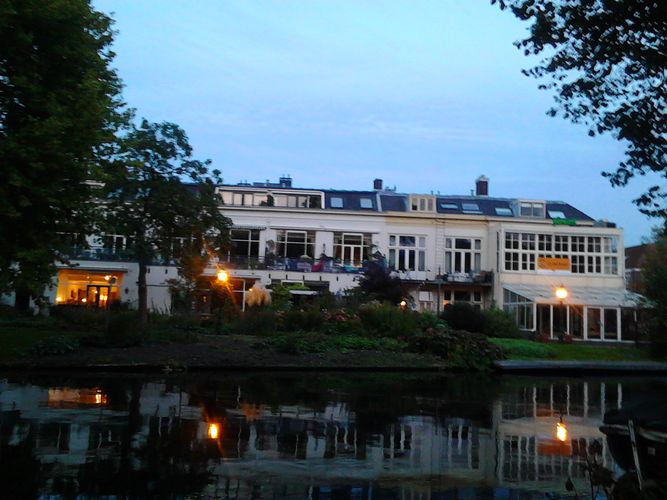 Hier sieht man ein Haus hinter einem Gewässer in Leiden.