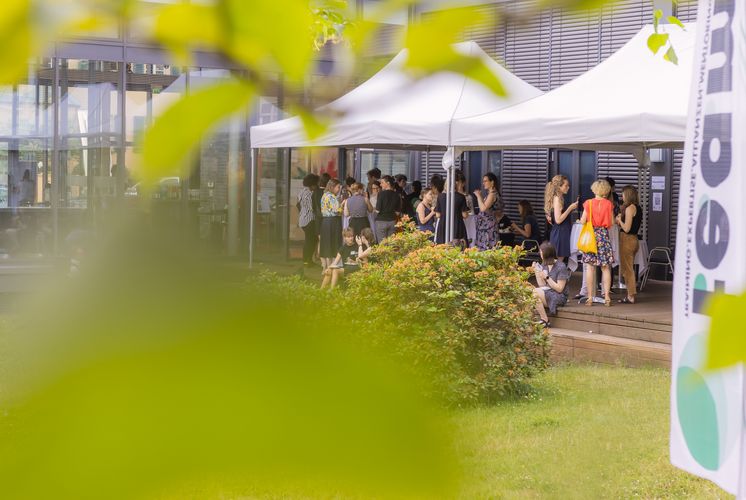 Personen stehen auf der Terrasse der Villa Ida und unterhalten sich bei Fingerfood und Getränken.