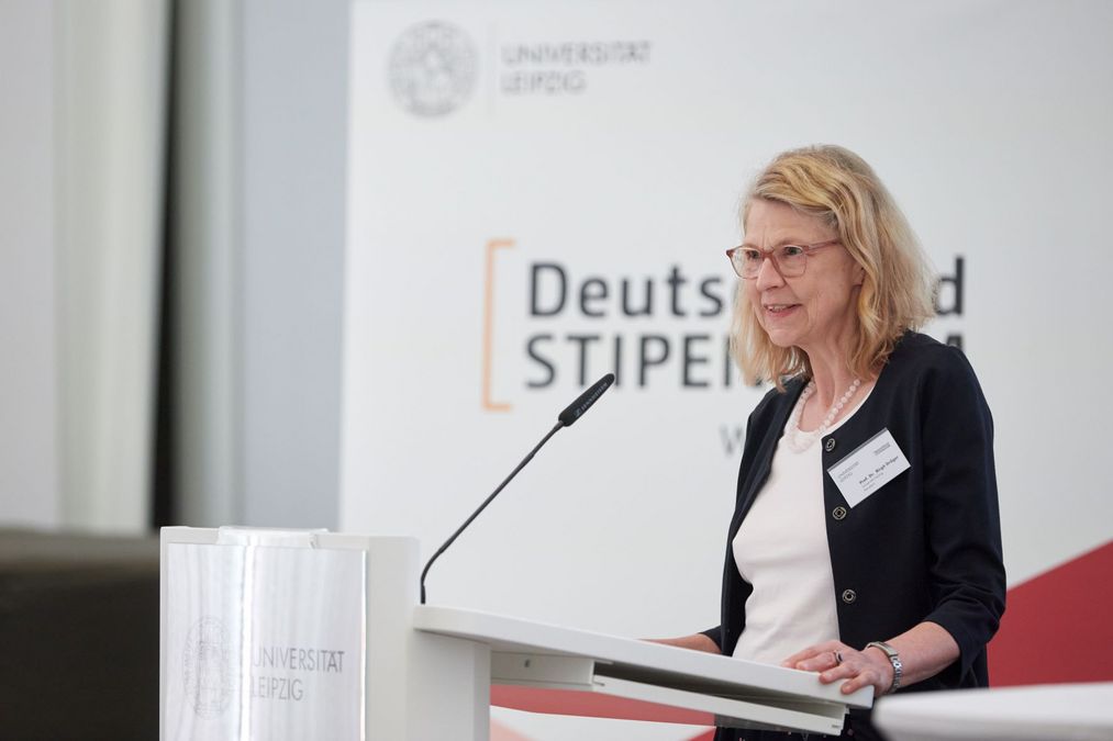 Farbfotografie: Kanzlerin Prof. Dr. Birgit Dräger steht seitlich zur Kamera am Rednerpult und spricht zum Publikum.