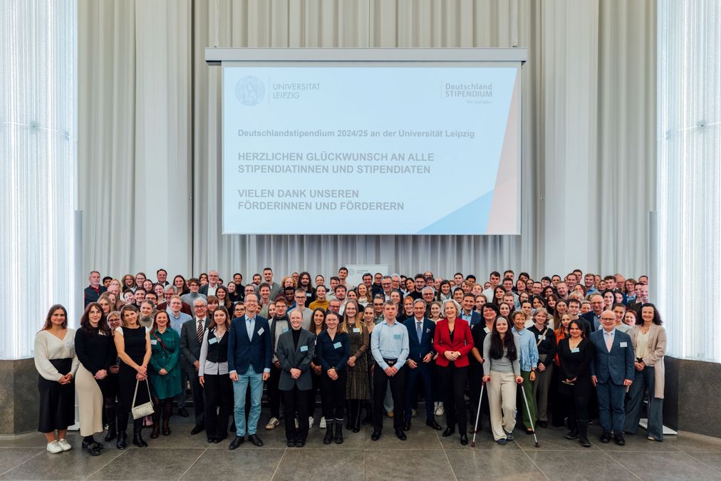 zur Vergrößerungsansicht des Bildes: Förderer und Stipendiaten des Deutschlandstipendiums stehen für ein Gruppenfoto zusammen auf der Bühne im Paulinum