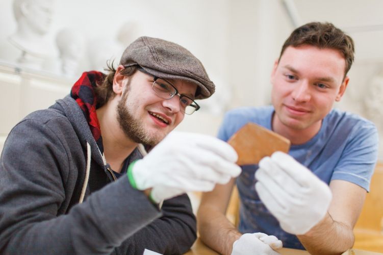 Zwei Studenten halten gemeinsam eine Scherbe mit Handschuhen, Foto: Christian Hüller