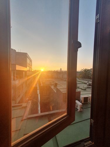 Blick auf den Sonnenuntergang aus einem Fenster