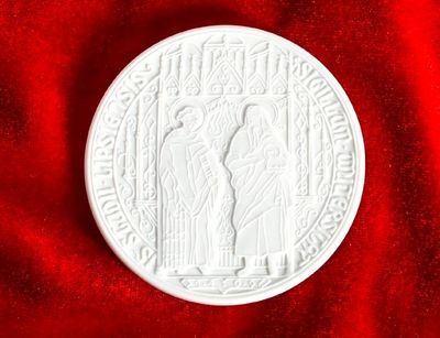 Vordersteite der Leipziger Universitätsmedaille, weiße Medaille auf rotem Samt