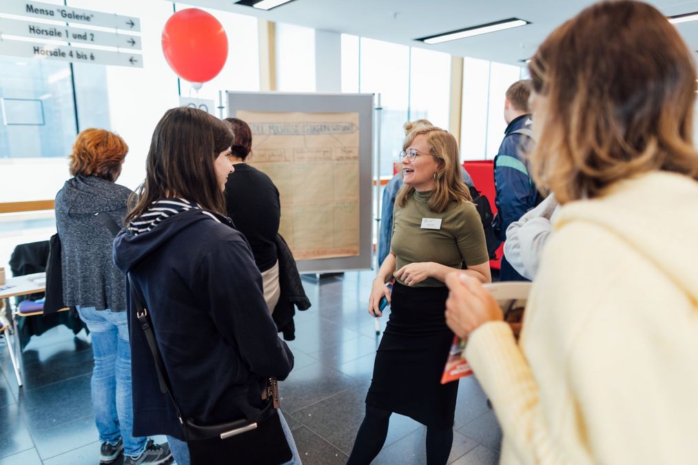 zur Vergrößerungsansicht des Bildes: Foto: Eine Lehramtsberaterin im Gespräch mit einer Besucherin.