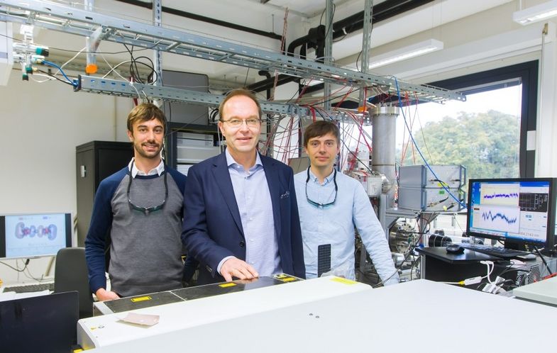 Prof. Dr. Knut R. Asmis mit den beiden Doktoranden Matias Fagiani (links) und Harald Knorke (rechts) vor dem Infrarotlaser des sogenannten Photodissoziationsspektrometers, mit welchem die bahnbrechenden Messungen zum Grotthuß-Mechanismus durchgeführt wurden.