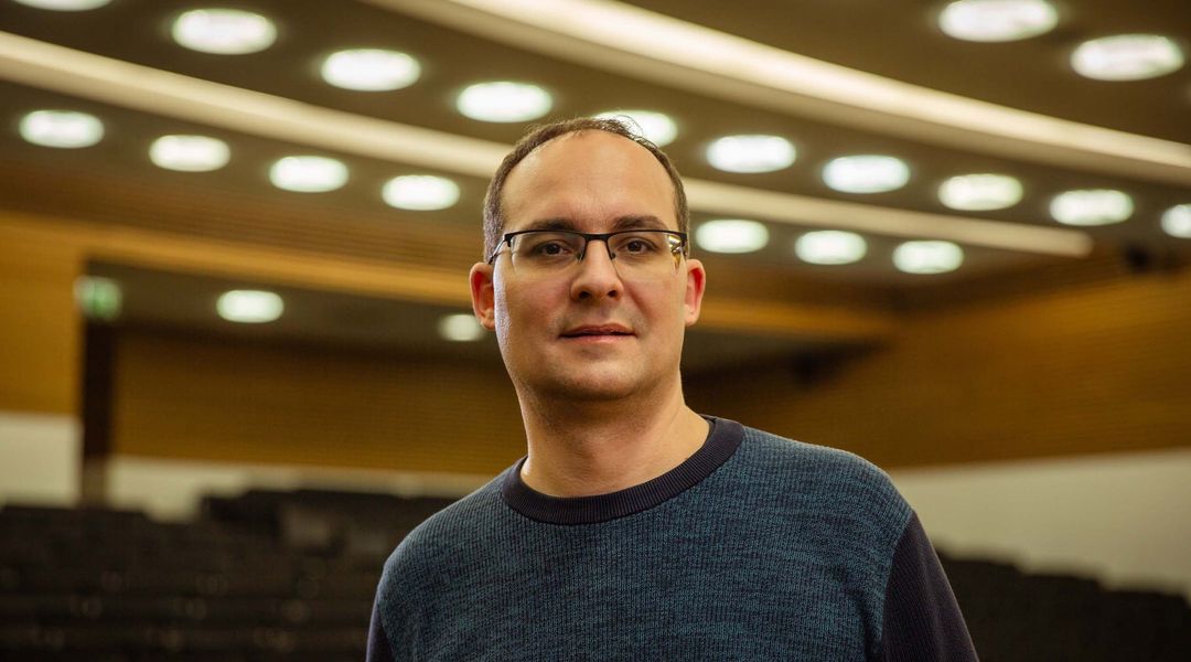 Porträtaufnahme von Professor Daniel Král' im Hintergrund ein großer Hörsaal