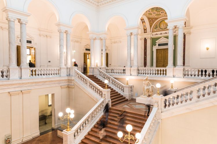 Blick vom ersten Stock auf die Treppen im Foyer der Bibliotheca Albertina, die von den Innenlaternen beleuchtet sind, Foto: Christian Hüller 