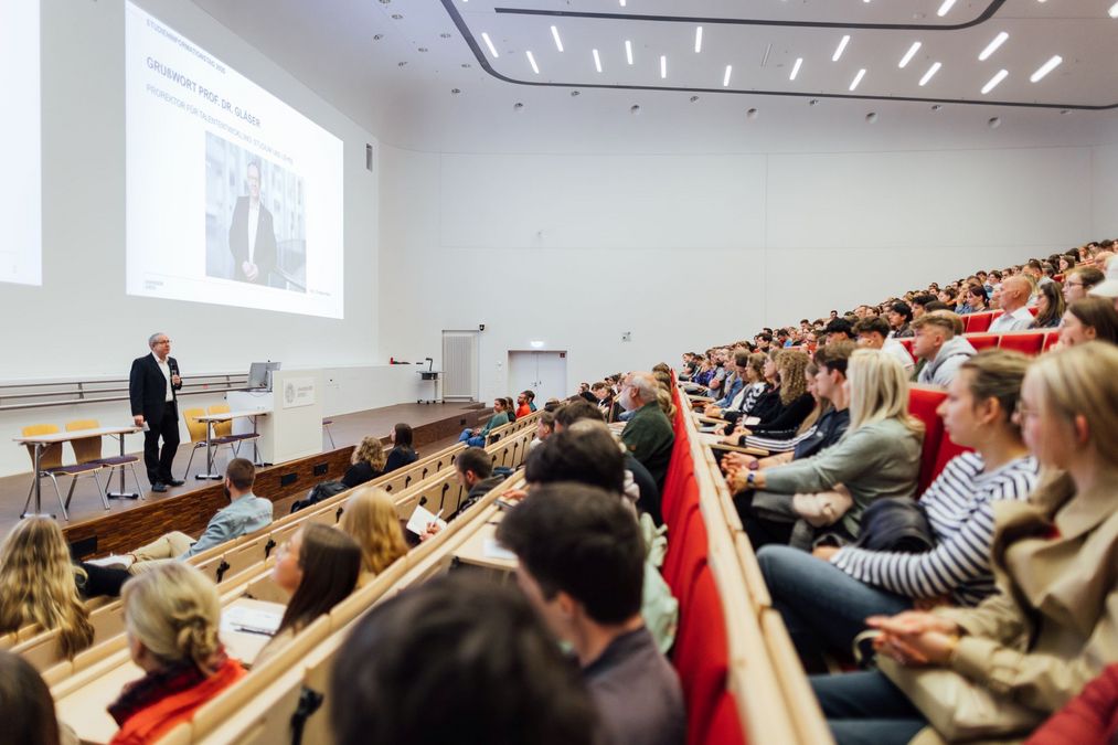 zur Vergrößerungsansicht des Bildes: Foto: Viele Besucher:innen bei der Eröffung des Studieninformationstags im Audimax, dem größten Hörsaal der Universität Leipzig.