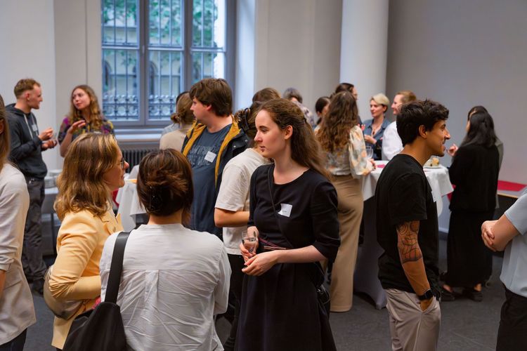 mehrere Mentees und Mentor:innen stehen im Vorraum und unterhalten sich vor Beginn der Veranstaltung. 