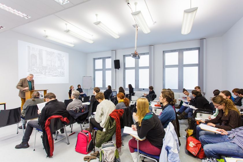 Studierende sitzen in einem Seminarraum und hören dem Professor zu, Foto: Christian Hüller