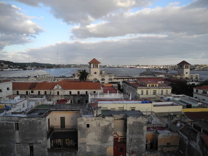 Das Bild zeigt den Blick auf kubanische Häuser sowie den Hafen Havannas im Hintergrund. 