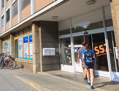 Foto: zwei Personen gehen in das Gebäude des Studien Service Center