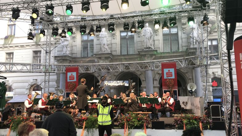 Das Bild zeigt eine Bühne im Rahmen des "Aufsteirern Festivals" in Graz, auf der ein Orchester spielt.