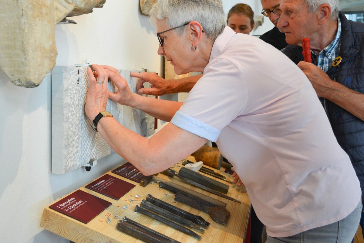 zur Vergrößerungsansicht des Bildes: Eine ältere Frau untersucht mit ihren Händen das Relief eines Ausstellungsstückes, Bild: Mandy Putz