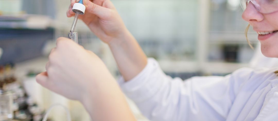 Foto: Studentin mit Schutzbrille arbeitet in einem Chemie-Labor