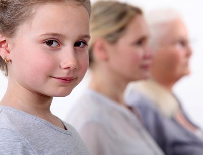 Drei Personen aus verschiedenen Generationen vom Kind bis zur Seniorin sitzen hintereinander..