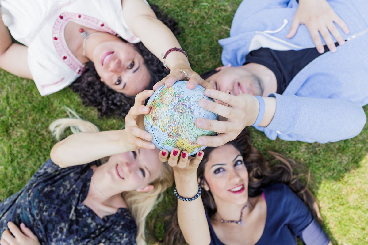 zur Vergrößerungsansicht des Bildes: Studierende der Universität Leipzig halten gemeinsam einen Globus in die Höhe. Nach ihrem Studium steht ihnen die ganze Welt offen.