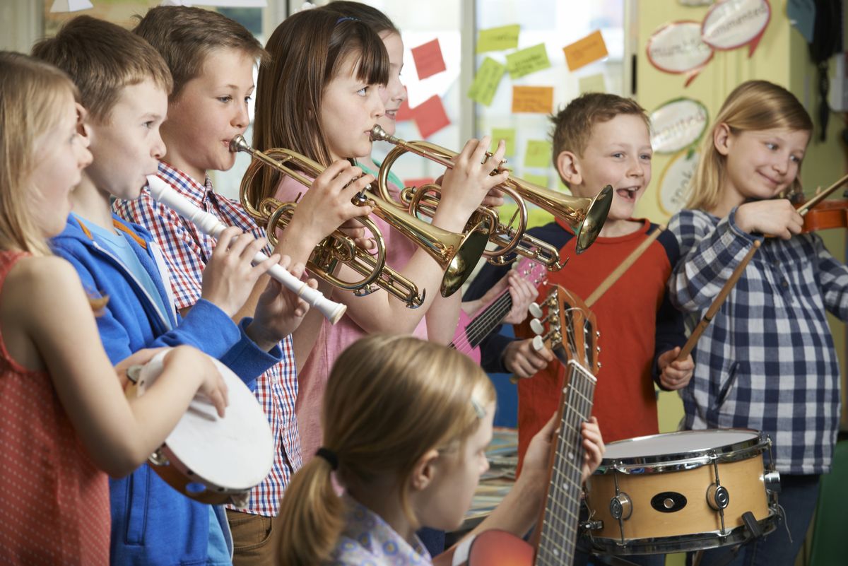zur Vergrößerungsansicht des Bildes: Man sieht Kinder, die gemeinsam verschiedene Instrumente spielen.