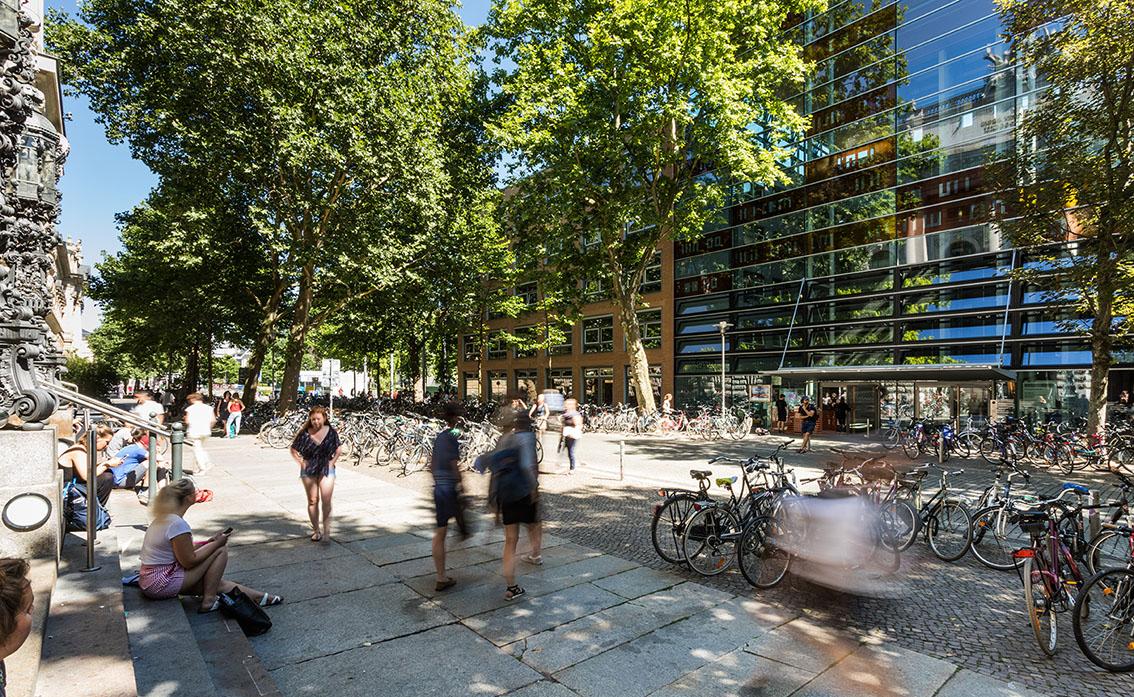 enlarge the image: Students in front of the university library. Their outlines are blurred because they are in motion