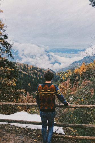Der Studierende blickt auf die Berge in Oberbozen.