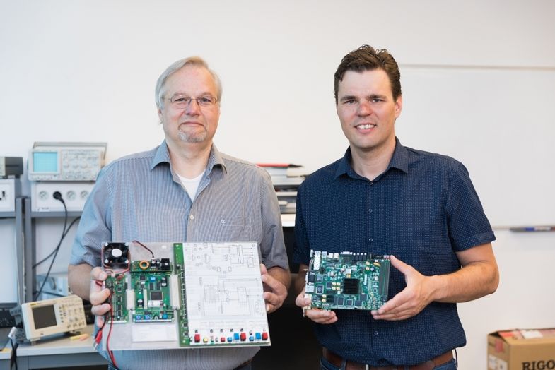 Prof. Dr. Martin Bogdan (links) und Jörn Hoffmann mit am Lehrstuhl eingesetzter Hardware zur Ausbildung sowie Forschung. Links der Minirechner für die Ausbildung, rechts ein Entwicklungsboard für die Forschung.