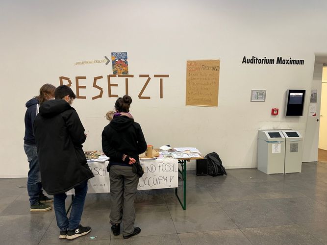 Blick auf einen Info-Stand vor dem besetzten Audimax.