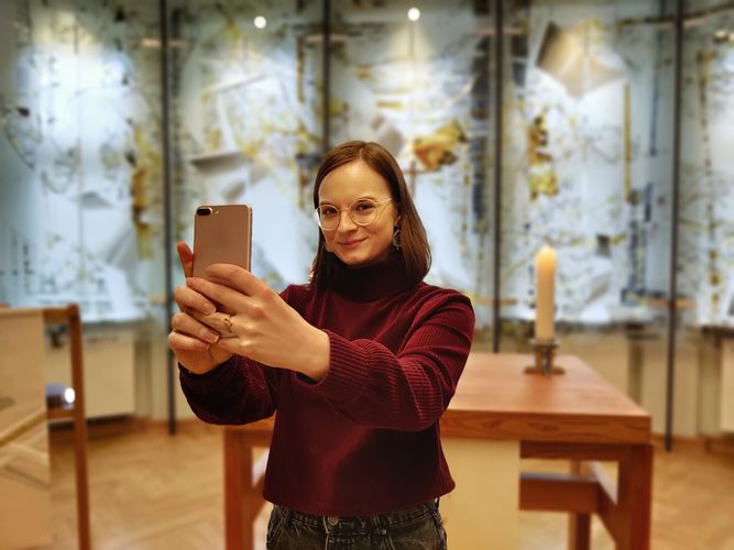 Kira Stütz, wie sie in einem Kirchenraum ein Selfie aufnimmt.