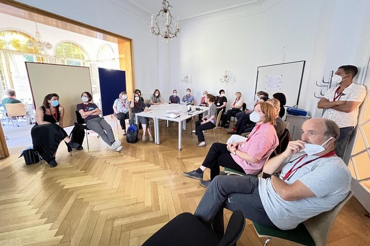 Mehrere Personen sitzen in einem Raum und diskutieren.