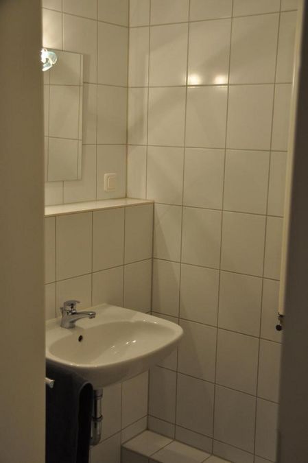 zur Vergrößerungsansicht des Bildes: Farbfoto: Innenansicht eines Badezimmers mit Waschbecken und Spiegel