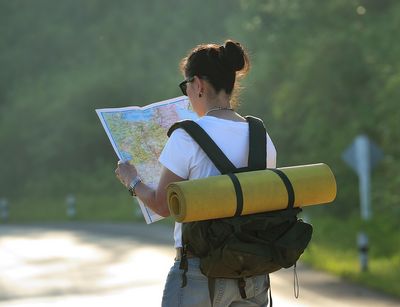 Young woman with backpack is looking at a map