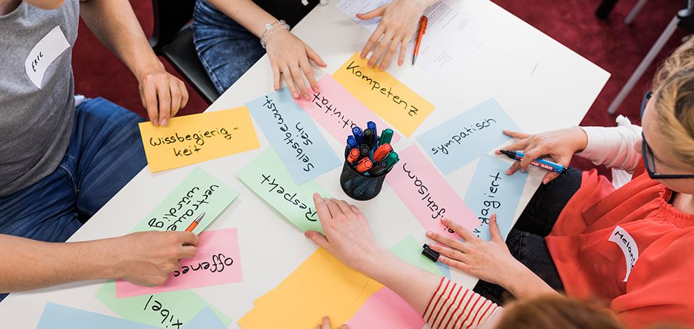 Viele bunte Zettel mit Notizen liegen auf dem Tisch