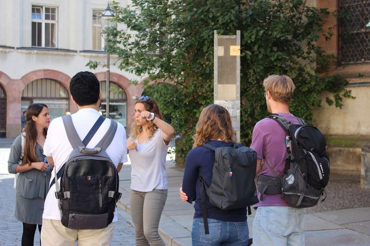 A group of young people standing on a public square and talking to each other.