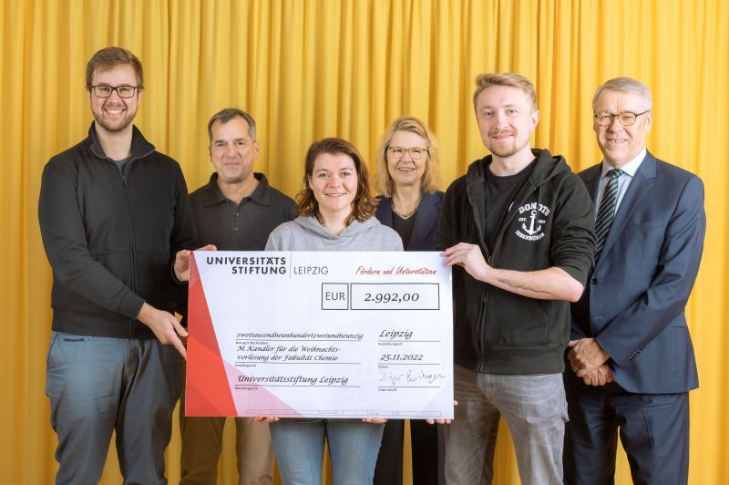 zur Vergrößerungsansicht des Bildes: Farbfoto: Prof. Dr. Birgit Dräger, Dr. Hubert Temmeyer und Prof. Dr. Harald Krautscheid von der Universitätsstiftung überreichen den symbolischen Scheck an die Fördermittelempfänger Marika Kandler, Silvan Allerbeck und Jannik Sälker