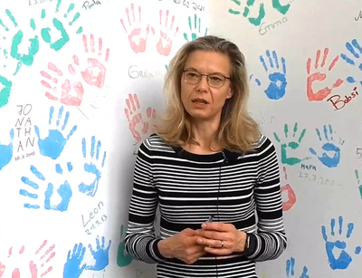 Prof. Dr. Antje Körner vor einer Wand mit vielen bunten Handabdrücken