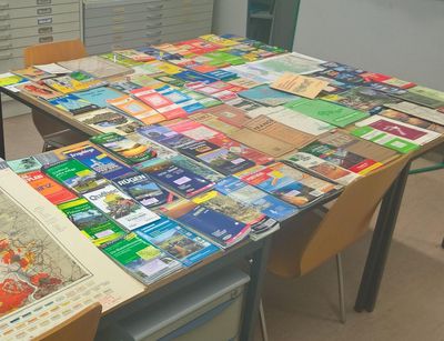 Verschiedene Exemplare der Kartensammlung der Universität Leipzig auf einem Tisch ausgebreitet.