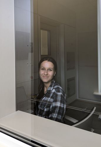 Junge Frau schaut durch eine Scheibe