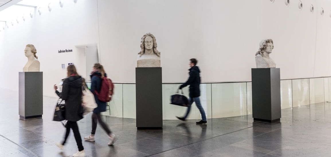 Studierende und Büsten vor dem Audimax im Foyer des Neues Augusteums