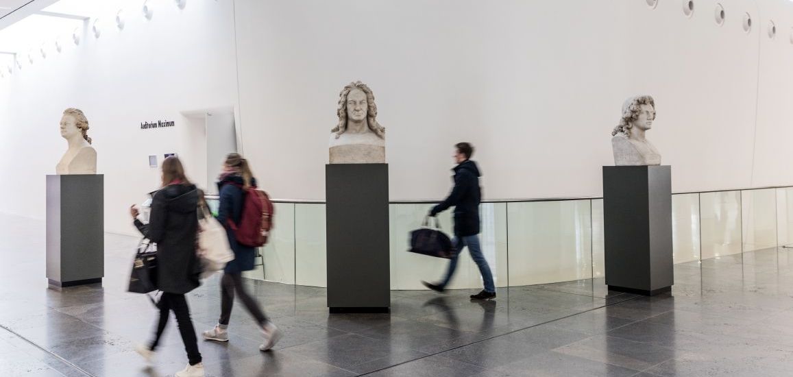Studierende und Büsten vor dem Audimax im Foyer des Neues Augusteums