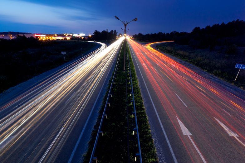 Langzeitaufnahme einer Autobahn mit Lichtbahnen, die durch die Lichter der Autos entstanden sind