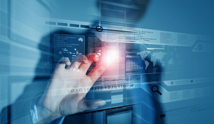 Computergrafik: Ein Mensch tippt auf ein virtuelles Display und Zahlencodes erscheinen. Im Hintergrund der Grafik steht eine Person in fotorealistischer Darstellung. Sie wendet sich Richtung Kamera und tippt mit dem rechten Zeigefinger wie auf eine Glasscheibe direkt vor ihr. Die Person ist nur zum Teil zu sehen, Kopf und Unterkörper sind angeschnitten. Die Person ist nur unscharf zu erkennen. Der Fokus des Bildes liegt auf dem Zeigefinger, der auf ein virtuelles Display tippt und damit Computerprogramme steuert und Daten abruft. An der Stelle, an der der Finger das unsichtbare Display berührt, entsteht ein heller Lichtpunkt.