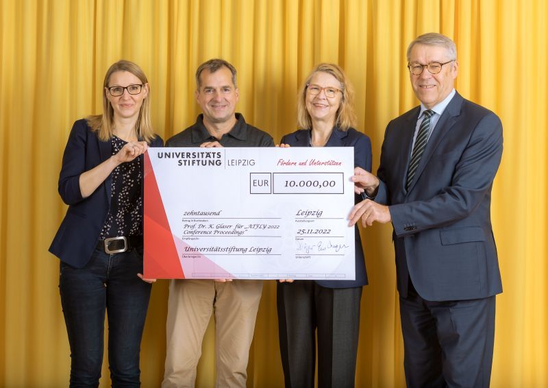 zur Vergrößerungsansicht des Bildes: Farbfoto: Prof. Dr. Birgit Dräger, Dr. Hubert Temmeyer und Prof. Dr. Harald Krautscheid von der Universitätsstiftung überreichen den symbolischen Scheck an die Fördermittelempfängerin Prof. Dr. Karen Glaser