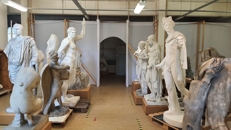 Mehrere griechische Statuen stehen in einem Raum