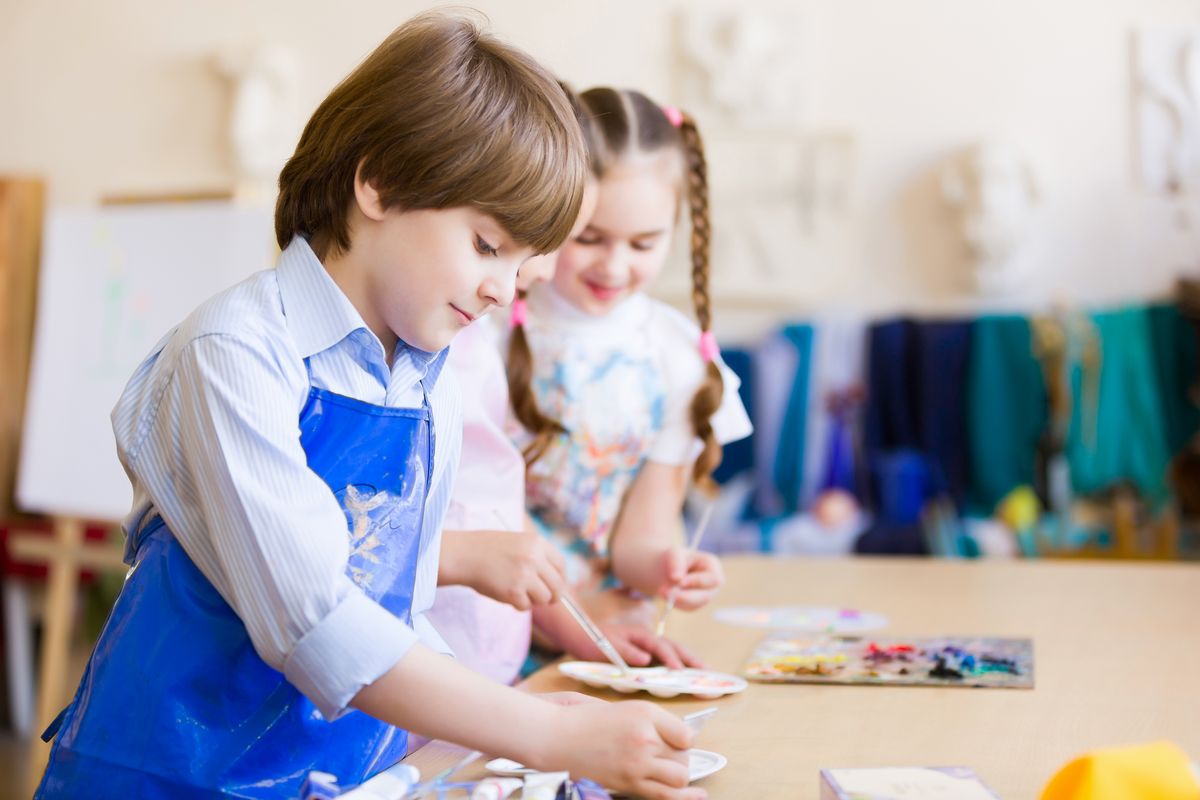 zur Vergrößerungsansicht des Bildes: Zu sehen sind zwei Kinder, die mit Ölfarben malen.