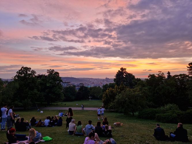 Menschen sitzen im Park und schauen dem Sonnenuntergang zu