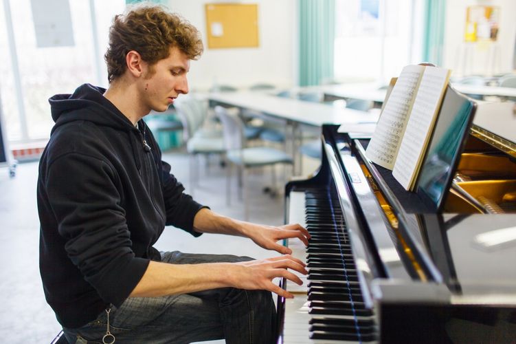 Student der Musikwissenschaft am Flügel im Seminarraum, Foto: Christian Hüller