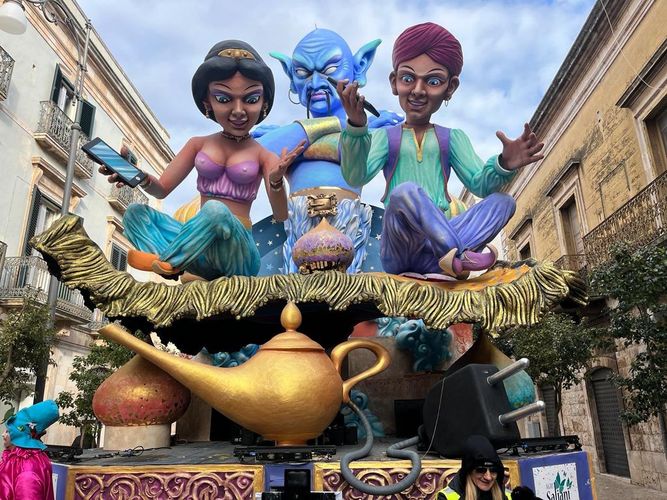 Farbfoto: Nahaufnahme einer Öllampe vor drei großen Figuren aus dem Märchen Aladin und die Wunderlampe