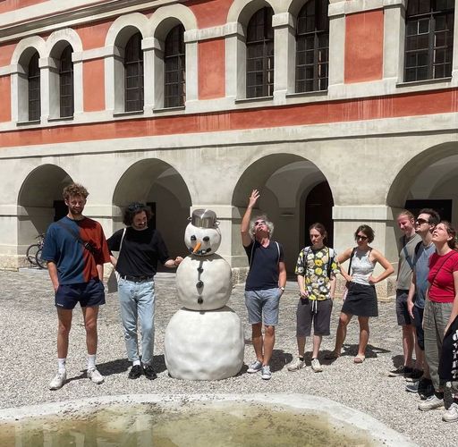 Zu sehen sind Studierende beim Besuch eines historischen Innenhofs.